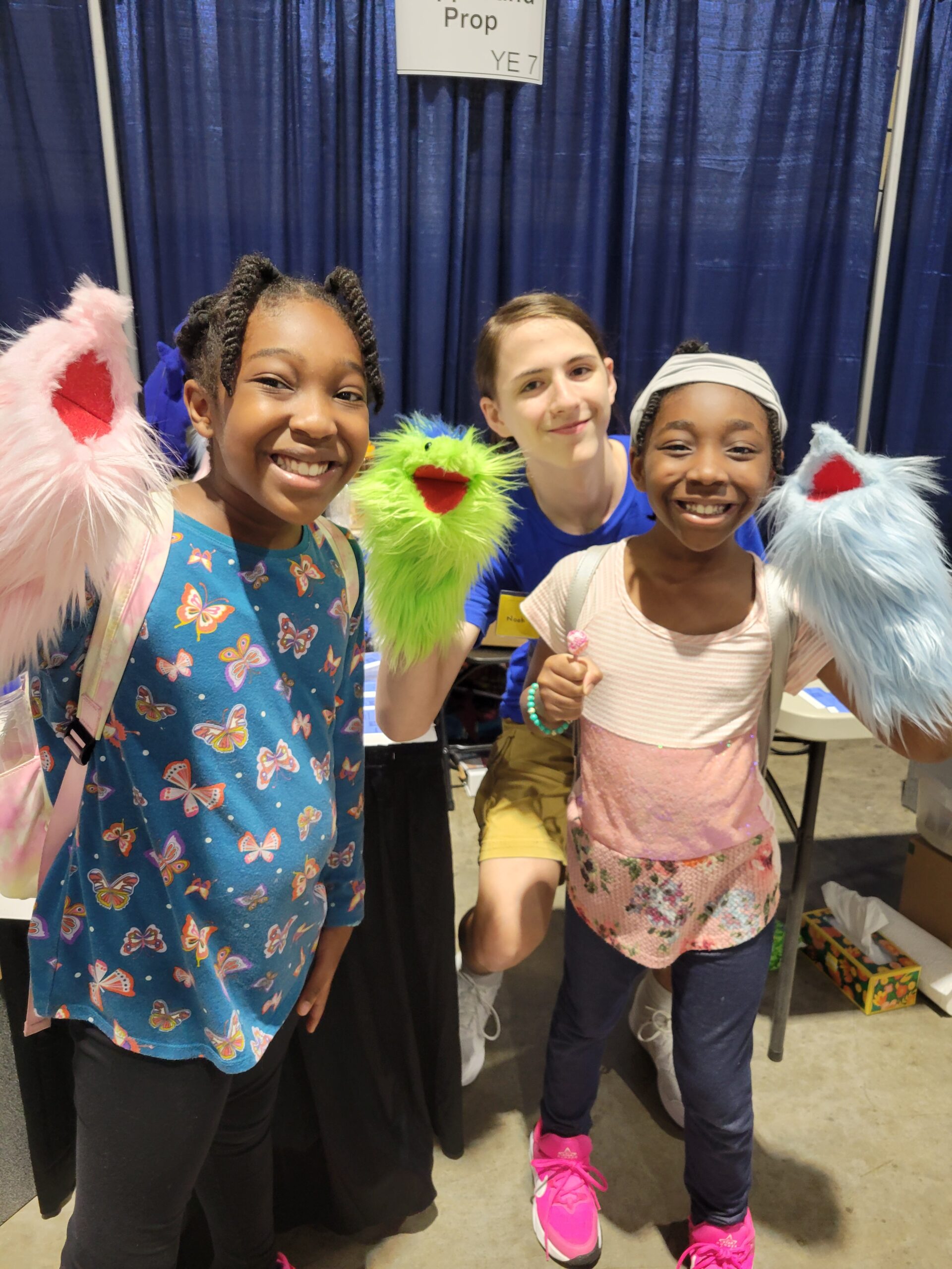 Three people holding puppets